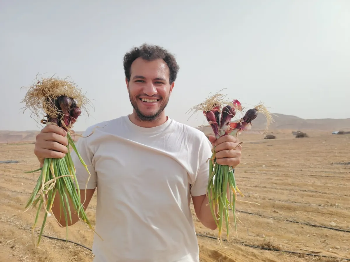Team member showing fresh garlic harvest
